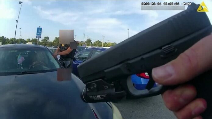 Esta imagen fija, tomada de un video de cámara corporal difundido por la policía del municipio Blendon el viernes 1 de septiembre de 2023, muestra un agente apuntando su pistola en dirección de Ta’Kiya Young, una mujer negra embarazada, momentos antes de dispararle a través del parabrisas frente a una tienda de comestibles, el 24 de agosto en el municipio de Blendon, Ohio, un suburbio de la ciudad de Columbus. (Policía del municipio Blendon vía AP)
