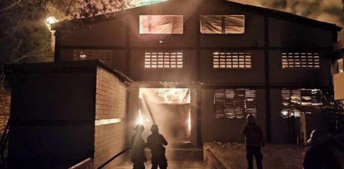 Desde la noche del viernes, unidades del Cuerpo de Bomberos de Santiago intentan apagar un incendio que afecta la instalación de una zona franca especial, dedicada a la fabricación de textiles, en Villa Liberación, la Otra Banda al suroeste de la ciudad.