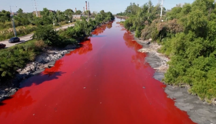 Agua color sangre fluye por un canal de Buenos Aires