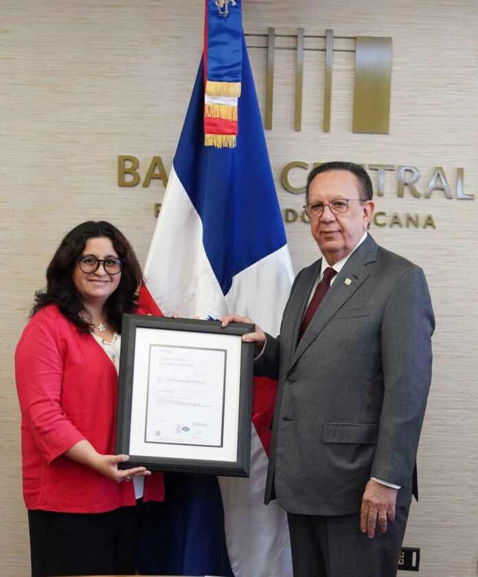 El gobernador del Banco Central de la República Dominicana (BCRD), Héctor Valdez Albizu, recibió el título que acredita que la institución completó con éxito el proceso de recertificación en Gestión de Seguridad de la Información bajo la norma ISO 27001:2022, extendiendo su alcance al proceso de Administración del Sistema de Liquidación Bruta en Tiempo Real (LBTR). El gobernador expresó que “éste es un logro más que atestigua el constante esfuerzo que el BCRD realiza desde el año 2012 para mitigar los riesgos y contribuir al fortalecimiento de la ciberseguridad en la región, otorgando así a los dominicanos un sistema de Gestión de Seguridad de la Información en el área financiera y de pagos conforme a los mejores estándares internacionales, situándose así en una posición favorable para afrontar los desafíos derivados de las amenazas emergentes”. Montserrat Aguilar, representante de la sociedad internacional de homologación con sede en Noruega, Dear Norske Veritas (DNV), señaló que “esta certificación valida que el Banco Central cumple con los lineamientos establecidos en la norma ISO/IEC 27001:2022, lo cual evidencia el esfuerzo continuo por mantener a la República Dominicana en los mejores parámetros de autodefensa ante los riesgos y contingencias que depara el manejo de la información”. Desde el año 2012, el BCRD ha mantenido esta certificación para el proceso de certificados de inversión, como resultado del compromiso asumido en cuanto al cumplimiento de los lineamientos establecidos en las distintas versiones de la norma ISO/IEC 27001. De este modo, el BCRD se mantiene en constante evolución conforme a las más avanzadas regulaciones y normativas en materia de seguridad cibernética y de la información. Las actividades de preparación para la auditoría externa realizada por DNV fueron coordinadas por el Departamento de Seguridad Cibernética y de la Información, con la colaboración de distintas dependencias del BCRD. El Banco Central fortalece y acredita con este logro la confiabilidad de las partes interesadas que intervienen en los procesos certificados, en todo lo concerniente a la seguridad y privacidad de la información. Para recibir el certificado, el gobernador estuvo acompañado del gerente, Ervin Novas Bello; el director del Departamento de Sistemas de Pago, Ángel González Tejada; el director del Departamento de Tesorería, José Gabriel Perdomo López; y el director del Departamento de Seguridad Cibernética y de la Información, Ruddy M. Simons Llauger.